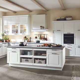 White framed kitchen cabinets with traditional kitchen elements in glass and shelving.