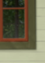 Light green house and green trim with burnt terra window