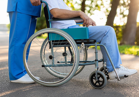 vecteezy_professional-caregiver-assisting-patient-in-wheelchair-outdoors_79597571.jpg