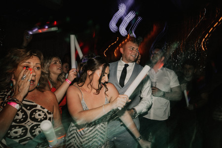 guests dancing with glowsticks on dancefloor at wedding