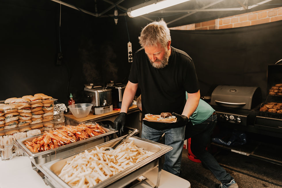 bbq server dishing up burgers chips and fish sticks onto plate
