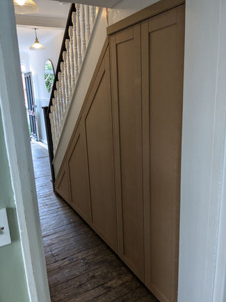 Bespoke Under-Stairs Storage with Pull-Out Shoe Drawers and Custom Shelving for Clients in Reigate Surrey by New Heights Carpentry.