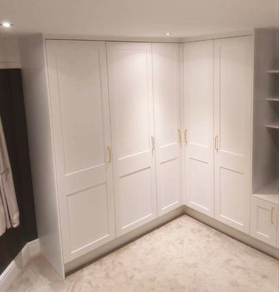Shaker style fitted wardrobe featuring bespoke shelving, drawers and hanging rails by New Heights Carpentry in Reigate, Surrey. Custom-built for functional and stylish storage.