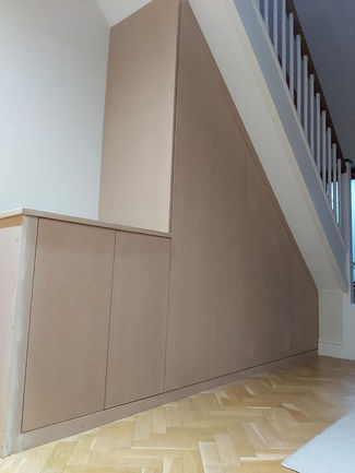 Bespoke Under-Stairs Storage with Pull-Out Shoe Drawer Hanging Rail Shelving and Wine Rack for a Client's Hallway in Reigate Surrey by New Heights Carpentry