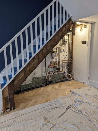Sleek Bespoke Under-Stairs Storage Solution with Four Large Doors Cabinets and Shelving for a Client in Redhill by New Heights Carpentry.