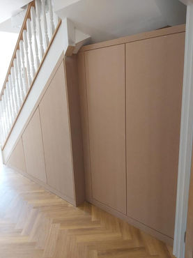 Bespoke Hallway Under-Stairs Storage with Hanging Areas Custom Shelving and Cabinets in Reigate Surrey by New Heights Carpentry.