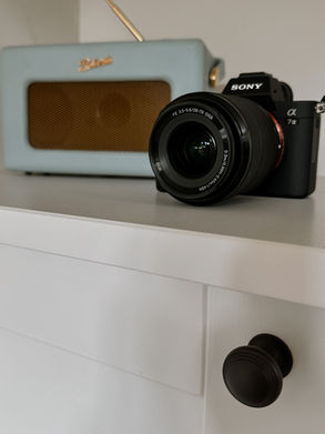 Custom shelving with pivot sliding doors, featuring four shelves on either side and two in the middle, part of a bespoke alcove desk unit in Reigate, Surrey.