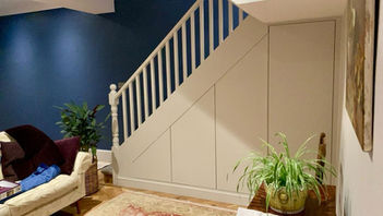 Sleek Bespoke Under-Stairs Storage Solution with Four Large Doors Cabinets and Shelving for a Client in Redhill by New Heights Carpentry.