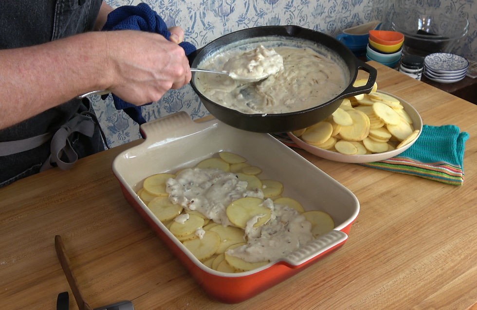 Layering sliced potatoes and creamy sauce in a baking dish for a mouthwatering scalloped potatoes recipe.
