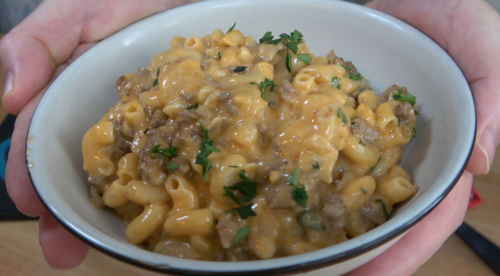 A comforting bowl of homemade hamburger helper, rich with cheesy pasta and savory ground beef, garnished with fresh herbs.