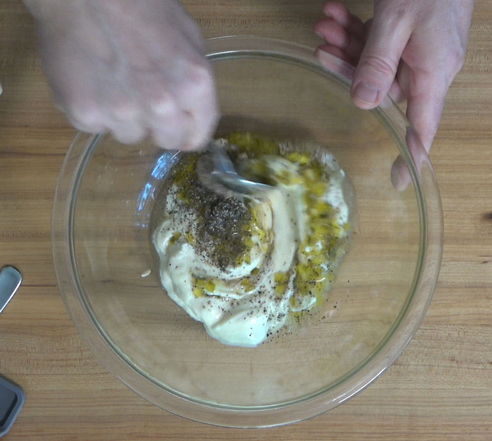 Mixing together fresh ingredients for a classic tartar sauce recipe.