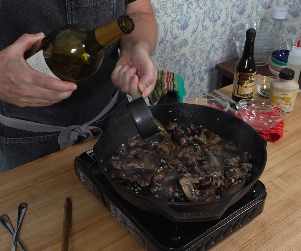 Deglazing a pan of sautéed mushrooms with white wine to create a flavorful base for creamy mushroom gravy.