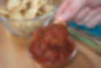 Savoring a corn chip loaded with rich, homemade Pace-style picante sauce, ready to delight the taste buds.