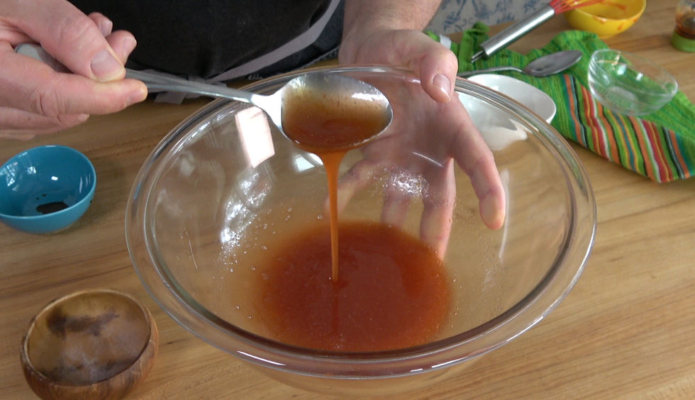 Crafting a homemade version of Chick-fil-A's Polynesian sauce, captured as it drips smoothly from a ladle into a glass mixing bowl.