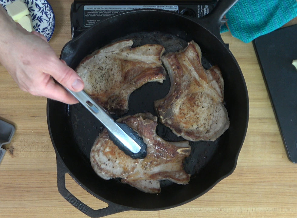 Sizzling pork chops in a cast iron skillet, perfectly seared to create a delectable base for a savory pan sauce.