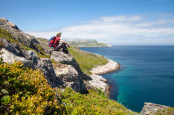 hiker sitting on coast