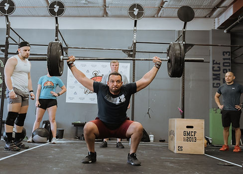 Male lifting barbell overhead