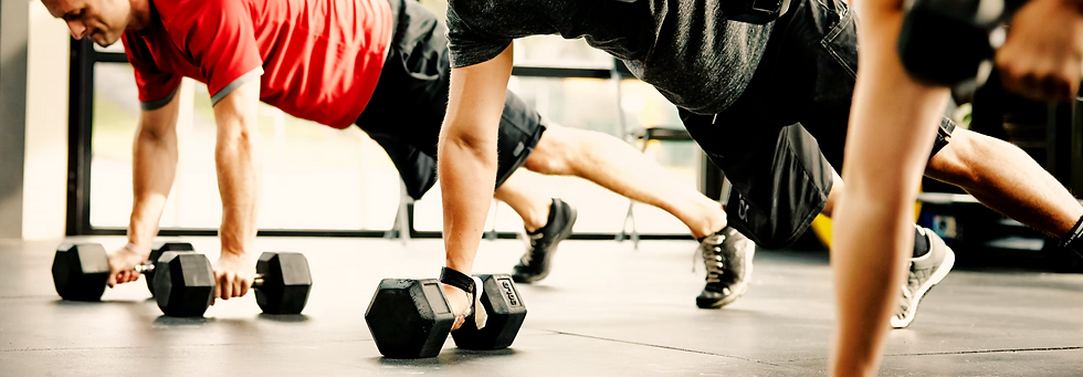 Group of people doing dumbbell push-ups in fitness class — Leonidas Vitality men's health membership and community