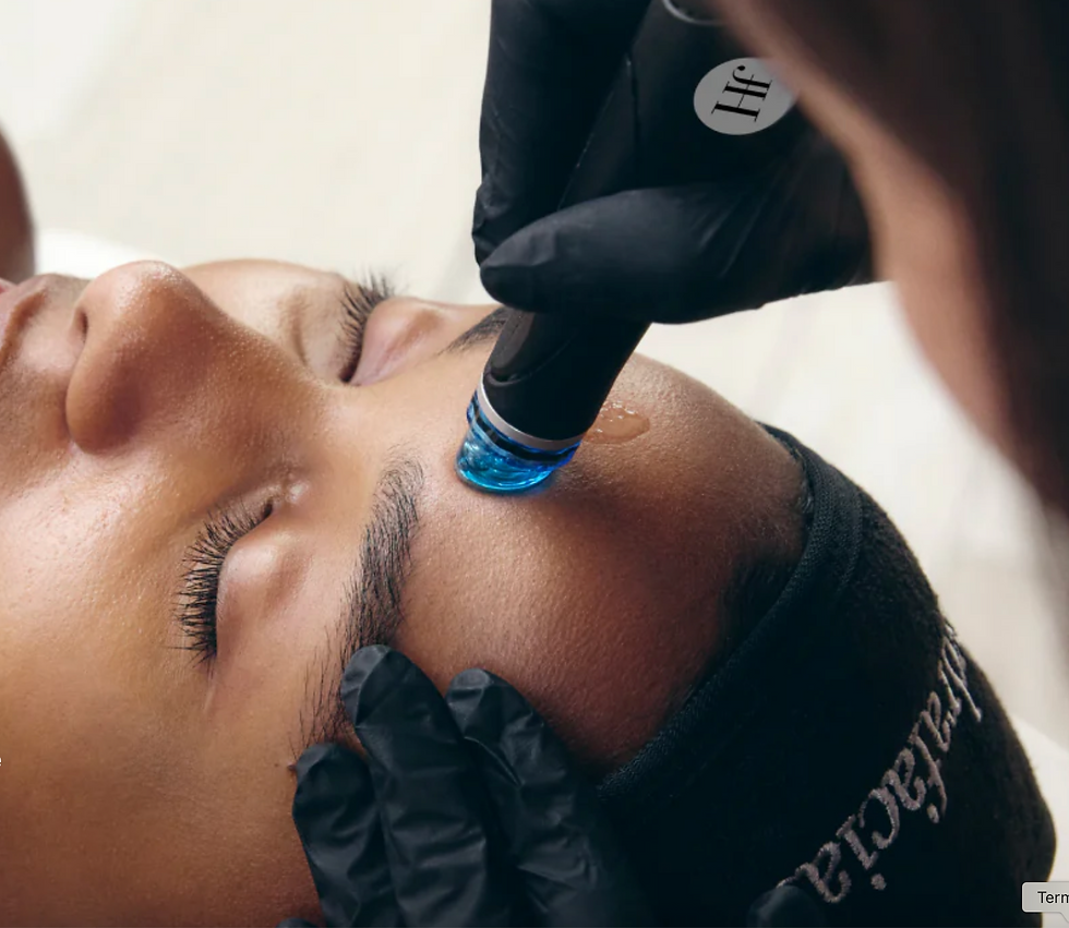 Woman with closed eyes receives a facial treatment from gloved hands using a skincare device in a spa room.