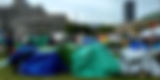 Downtown Toronto encampment with tents and protest signage reflecting rising civic unrest and social tensions in Canadian urban spaces