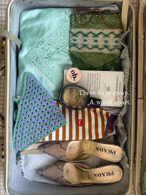 Valigia aperta per un weekend di tre giorni con abiti coordinati, libro, profumo e bandana crochet Zigzagoo