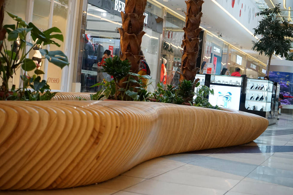 Modern parametric wood bench with integrated planter, flowing sculptural layered design, natural finish, and organic curves —