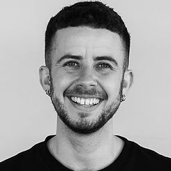 Julian standing indoors and smiling happily