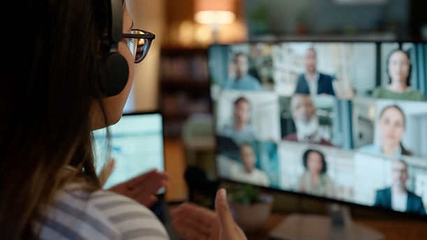 A person sitting at their desk, speaking during a video conference call