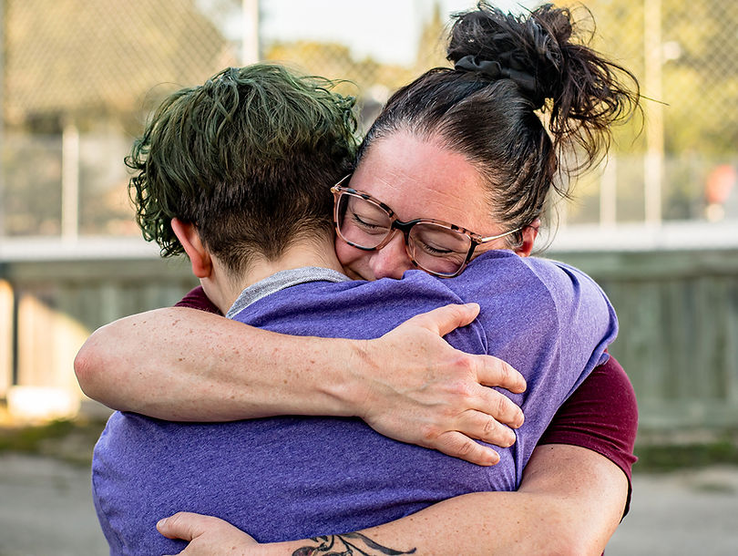 A mother hugging her teenage non-binary child