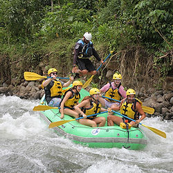 Grupo practicando rafting clase 2-3 en rápidos de un río