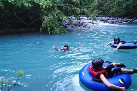 Personas en flotadores sobre las aguas celestes del río.