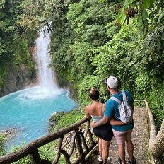Pareja viendo la cascada de Río Celeste desde escaleras