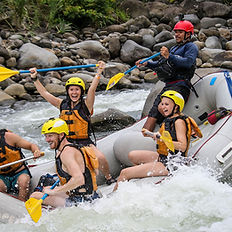 Grupo practicando rafting clase 2-3 en un río con rápidos