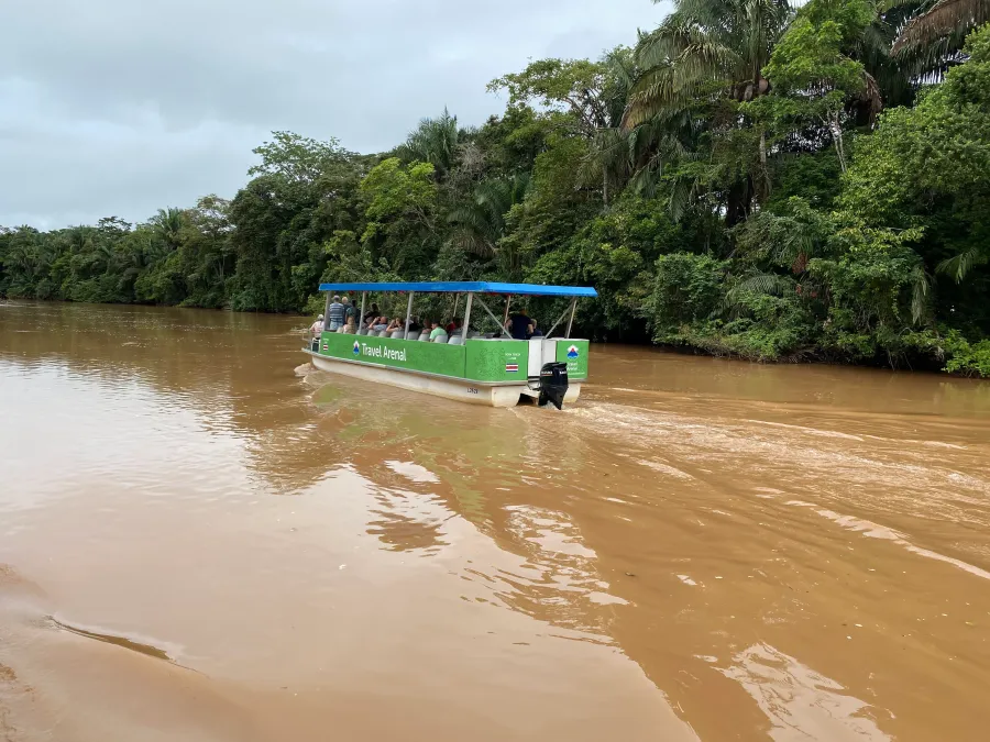 Bote turístico navegando el río en Caño Negro Tour.