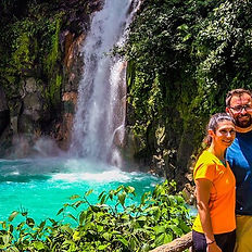 Pareja posando frente a la catarata de Río Celeste.