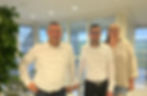 Three members of the BFE service management team stand in a modern office building, from left to right: Markus Meder, Fabio Di Felice and Vanessa Pakulat.