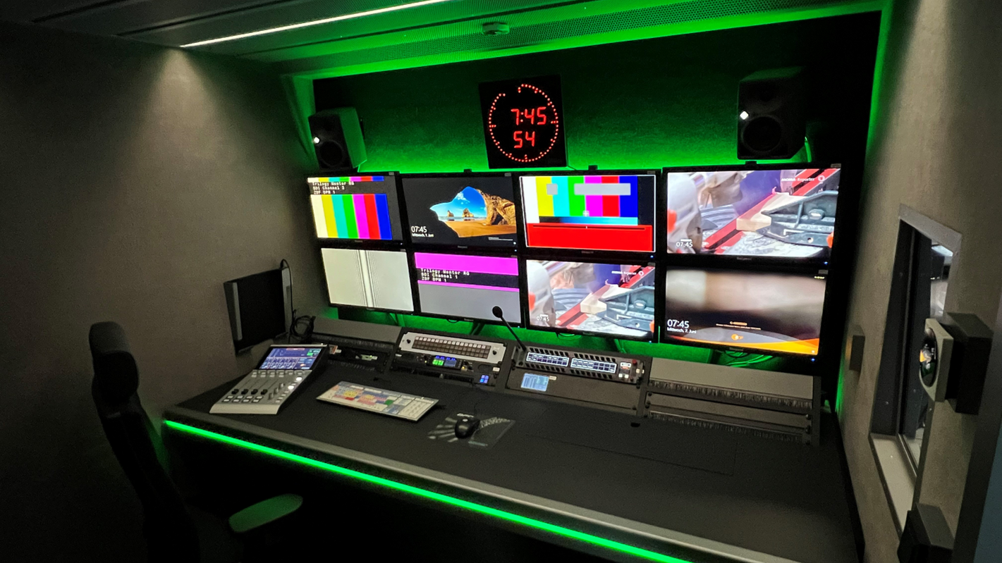 Regieraum der von BFE entwickelten ZDF-Produktionsmobile DPM1 und DPM2 mit mehreren Monitoren, Audiomischpult und grüner Ambientebeleuchtung für optimale Arbeitsatmosphäre.