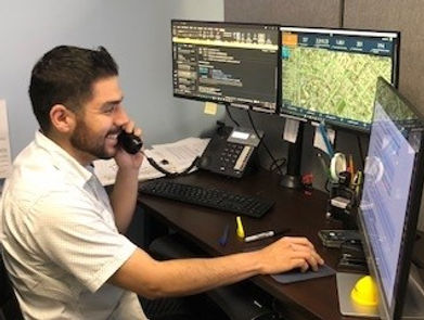 Employee talks on phone while looking at his computer
