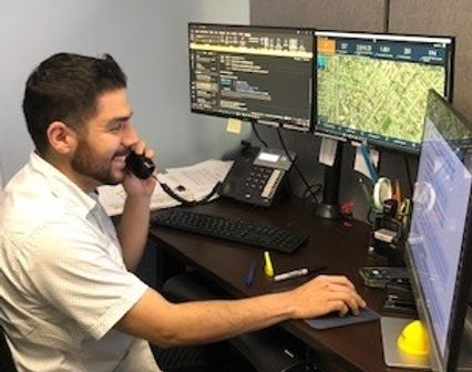 Employee talks on phone while looking at his computer