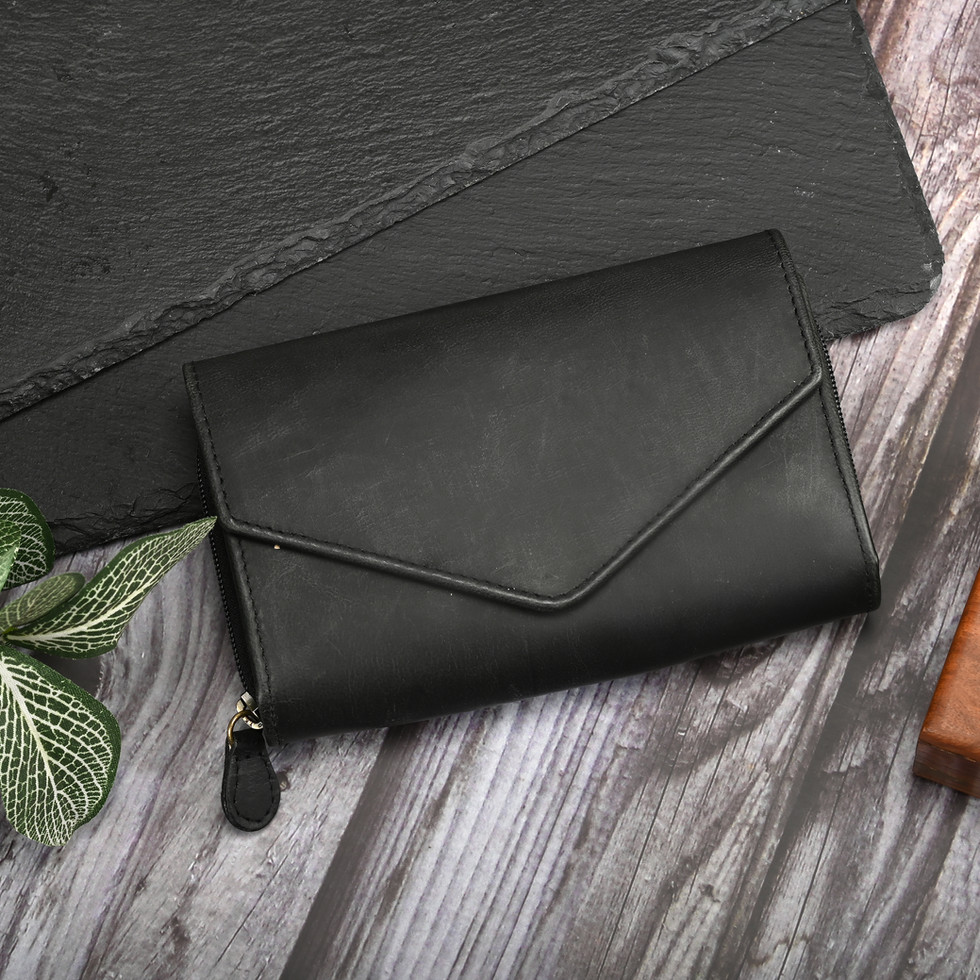 Black leather wallet with zipper, close-up on a wooden surface and slate.