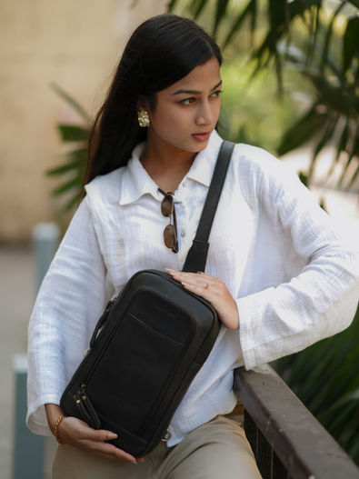 Woman wearing a white shirt and black sling bag with background Vintanaro.