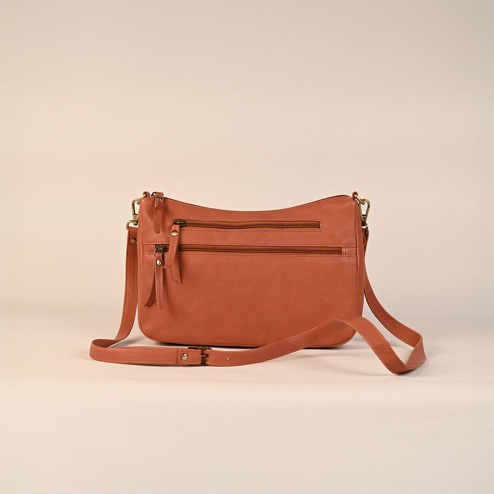 Orange leather handbag with two front pockets and long adjustable strap. Feather Touch Impex Pvt. Ltd.