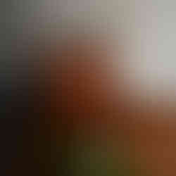 Brown leather tote bag with cosmetics and wristwatch on surface.