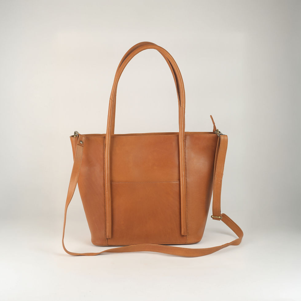 Brown leather tote bag with shoulder strap against a white background