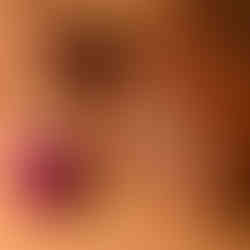 Brown leather bag beside artificial flowers on a warm brown surface