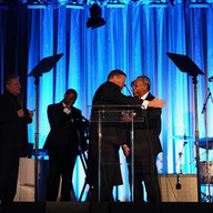 Two men on the stage talking