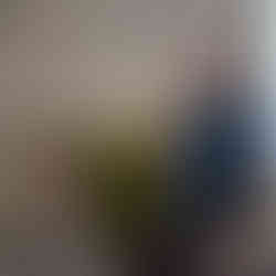 A man presenting next to a person sitting.