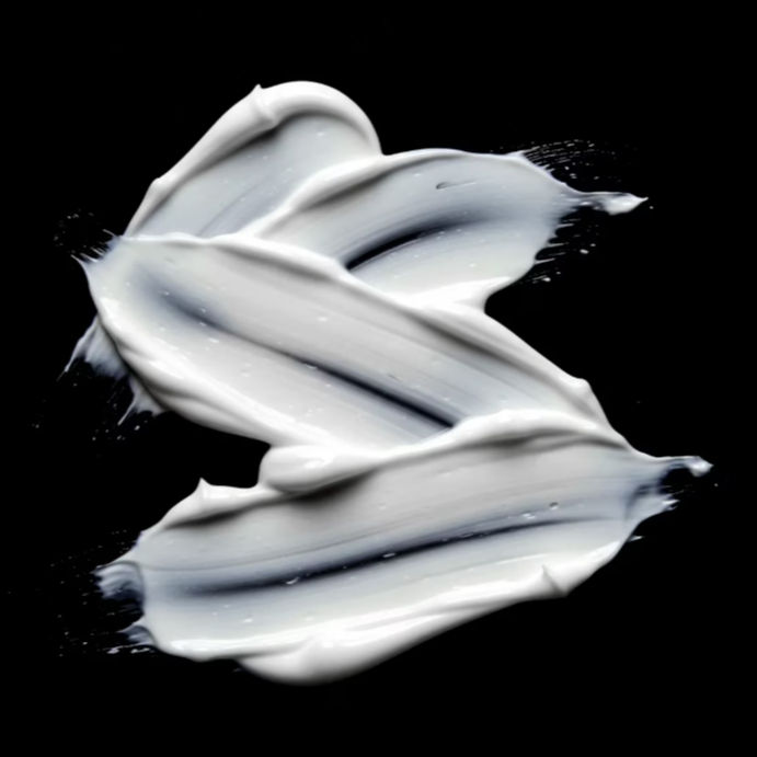 Smooth white conditioner texture on black background