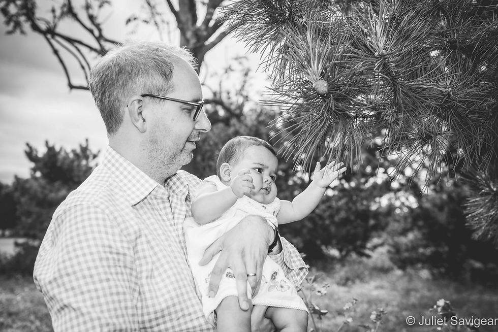 Baby touching pine leaves