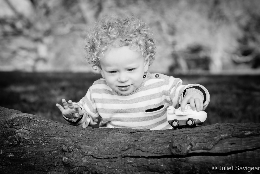 Toddler playing on a log